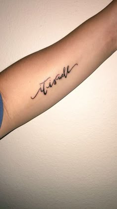 a woman's arm with the word tattoo on it and her name written in cursive font