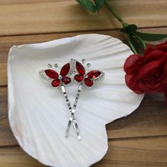 A beautiful pair of red and clear crystal butterflies are a beautiful accent to these shiny silver bobby pins. A Positive Associations with the color red is that we think of vitality, the life-giving power of blood, and helping people in need (think American Red Cross.) We give red roses when we're in love, and call simply outstanding experiences "red letter days." The butterfly is  associated with new beginnings and fresh starts, symbolizing rebirth and new phases of life. Additionally, butterf Silver Red Hair, Butterfly Hair Pins, Silver Bobby Pins, Crystal Butterflies, Butterfly Crystal, Fresh Starts, Garnet Red, American Red Cross, Crystal Butterfly