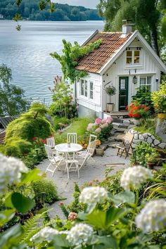 a small white house sitting on top of a lush green hillside