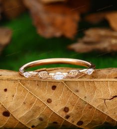 a wedding ring sitting on top of a leaf