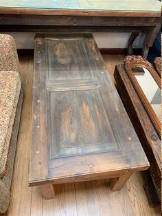 an old coffee table and couch in a room with wood flooring on the ground