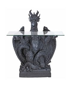 a glass topped table with a dragon and demon statue sitting on it's side