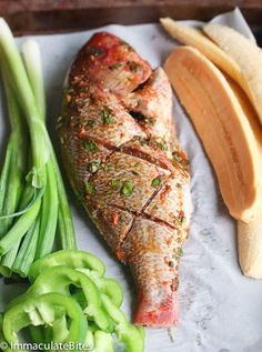 fish, green beans and sliced bananas on a white paper with a wooden tray in the background