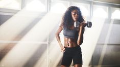 a woman is holding a camera and posing for the camera