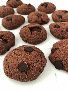 chocolate cookies are arranged on a white surface