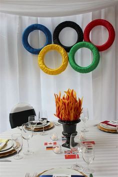 an olympic themed table setting with plates, forks and napkins on the place settings