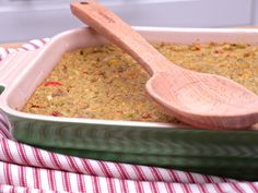 a casserole dish with a wooden spoon in it on a red and white towel