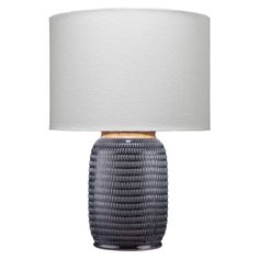 a gray table lamp with a white shade on the top and gold trim around the base