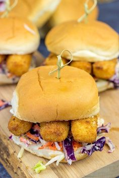 two chicken sliders with coleslaw slaw on them