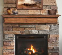 a fire place with a painting above it