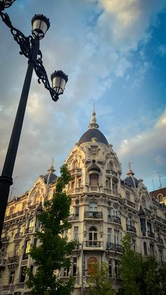 an ornate building with many windows and balconies on the top, under a cloudy blue sky