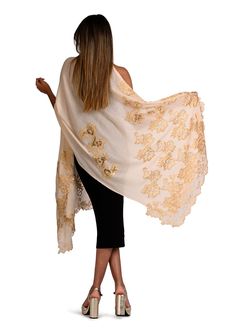 Woven from the finest cashmere, this beige scarf features an intricately handcrafted application of an exotic gold Chantilly lace extending inward in a vine pattern from the ends of the scarf. The luxurious cashmere fabric ensures both warmth and comfort whilst the stunning lace application adds a touch of sophistication with unparalleled charm, giving this scarf timeless appeal with a modern edge. You can style yourself with versatile ease in multiple ways, making this scarf the perfect accesso Elegant Cream Pashmina Shawl In Traditional Drape, Elegant Scarves With Chikankari Embroidery, Elegant Chikankari Embroidery Scarf In Traditional Drape, Luxury Festive Shawl, Elegant Beige Pashmina Shawl With Traditional Drape, Elegant Silk Pashmina Shawl With Intricate Embroidery, Elegant Cream Shawl Dupatta, Elegant Pashmina Dupatta With Intricate Embroidery, Elegant Embroidered Pashmina Silk Scarf