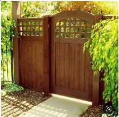 a wooden gate in the middle of a garden