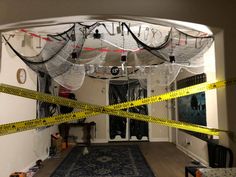 a room with yellow caution tape on the floor and black curtains hanging from the ceiling