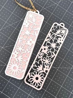 two pink and white bookmarks sitting on top of a table next to each other