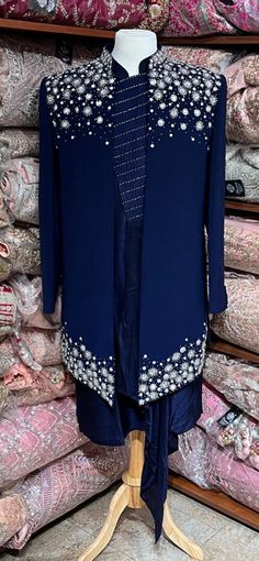 Midnight blue exclusive embellished with intricate pearl, stone, zari and cutdana work, this sherwani speaks volume of class. Commingled with blue color kurta for the complete ensemble. This jacket sherwani is a unique style that we loved. Even the color is fresh and looks royal. Size: 42,44 Occasion: Wedding Ceremony or Reception WASH CARE INSTRUCTIONS - Please Dry clean only when it is applicable. Slight color variation is possible due to digital photography. Ready to Ship! Blue Bandhgala With Mirror Work For Festive Occasions, Blue Bollywood Bandhgala With Mirror Work, Blue Bandhgala With Mirror Work For Wedding, Wedding Blue Bandhgala With Mirror Work, Blue Embellished Bollywood Kurta, Blue Bollywood Style Embellished Kurta, Embellished Bandhgala For Eid, Formal Nehru Jacket With Mirror Work, Formal Blue Kurta With Mirror Work