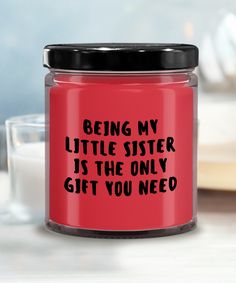 a red glass jar with the words being my little sister is the only gift you need