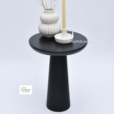 a black table with two white vases on it