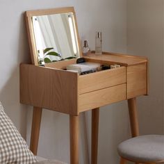 a wooden dressing table with a mirror and stool