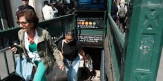 two women are walking down the stairs with their luggage in hand and one woman is holding her purse