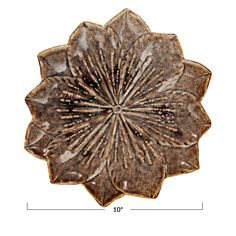 a large brown flower shaped object on a white background, with measurements for the petals