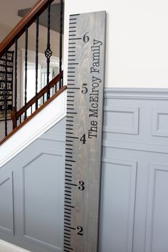 a tall wooden ruler sitting next to a stair case