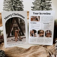 two christmas cards sitting next to each other on top of a wooden table covered in pine cones