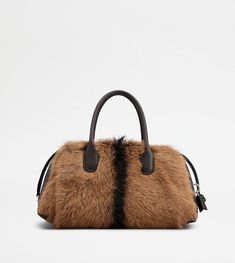 Characterized by maxi zip pulls, straps that elegantly cover the zip when closed, Tod's Darsena is defined by essential and feminine lines. Featuring characteristic tubular handles, it comes with a wrapped side padlock, a sophisticated distinctive trait. Here in fur and smooth leather, it is a model with a distinctly urban nature, named after the city of Milan. Violet Brown, Urban Nature, Gift Boutique, Bags And Accessories, Pink Beige, Grey And Gold, White Beige, Medium Brown, Yellow And Brown