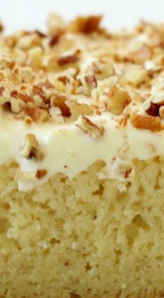 a piece of cake with white frosting and nuts on top