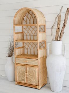 a white vase sitting next to a wooden cabinet