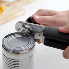 a person using a can opener to open a can