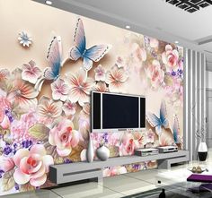 a living room with flowers and butterflies painted on the wall next to a flat screen tv