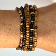 This beautiful bracelet stack pairs classic black with shades of golds, browns, and ambers for a timeless combination perfect for dressing up or going casual. Switch it up by rearranging them, or add them to some of your existing favorites for a new twist on your accessorizing.   Included are five individual stretch bracelets: black and gold; caramel and chocolate; multi brown and amber; wood; and solid black. As a handmade item, each set will vary slightly due to randomization of the multi bead patterns. Giving as a gift? The 7" size is considered "standard" and fits a lot of teens and adults. Treating yourself? Measure your wrist to choose your desired size. Selecting a set that's a little larger means the stack will slouch down on your wrist, and just right or smaller will fit more snug Brown Stretch Bracelet With Stackable Round Beads, Brown Stackable Stretch Bracelet With Round Beads, Brown Stackable Bracelet With Round Beads, Spiritual Brown Beaded Bracelets For Everyday, Brown Stackable Beaded Bracelets Gift, Gift Stackable Brown Beaded Bracelets, Gift Brown Stackable Beaded Bracelets, Earthy Brown Bracelets For Everyday Wear, Earthy Brown Bracelets For Everyday