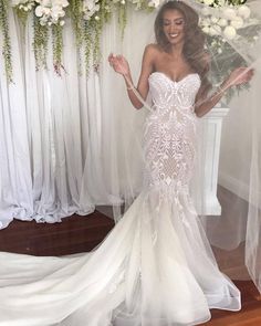 a woman standing in front of a window wearing a wedding dress with sheer veils