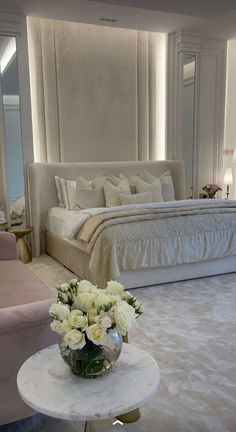 a bedroom with a large bed and white furniture