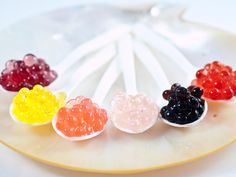 five gummy bears sitting on top of a white plate