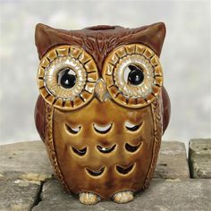 an owl figurine sitting on top of a stone slab with eyes wide open