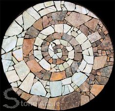 a circular stone table top sitting on wooden pallets