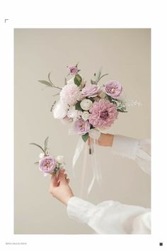 two hands holding pink and white flowers in each other's hand, with one being held by the other