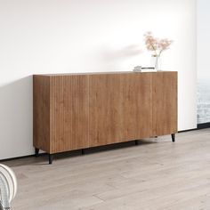 a wooden cabinet sitting on top of a hard wood floor next to a white wall