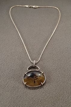 I am offering you this fabulous vintage sterling silver (stamped) there is a large oval shaped shaded striated cream colored /taupe colored agate in a large oblong shaped pendant charm, and necklace chain.  It features a gorgeous huge shaped setting, with spectacular large all stone coverage. The necklace chain is a woven snake link chain, that measures app. 16 inches long. It measures app.  1.75 inches, by app. 1.25  inch. It weighs app. 6.5 grams.  Please review all of my pictures, as they are Unique Oval Necklace With Polished Finish, Formal Oval Agate Necklace, Silver Necklace With Oval Pendant And Vintage Charm, Unique Oval Silver Necklace, Collectible Oval Necklace With Large Stone, Vintage Oval Necklace With Large Stone, Vintage Oval Jewelry With Large Stone, Vintage Oval Sterling Silver Necklaces, Vintage Oval Large Stone Necklaces