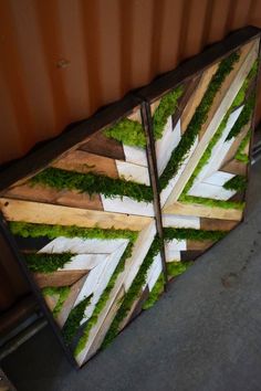 two pieces of wood with moss and white arrows on them sitting next to each other