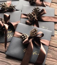 four wrapped gift boxes with pine cones on them