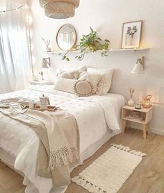 a bedroom with white walls and wooden flooring is decorated in neutral tones, such as linens on the bed