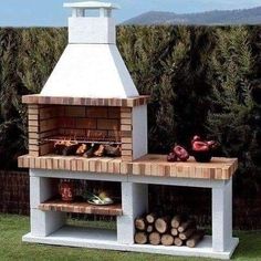 an outdoor pizza oven with lots of wood stacked on it's sides and shelves