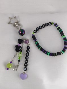 a bracelet with beads and charms is laying on a white surface, next to a star