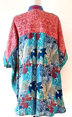 This version of the Tunic Top is fresh, comfortable, and stylish. Move over classic button downs, tunics are taking over! Kantha style stitched cotton creates interest and elevates the tunic. A-line cut is roomy, falling just below the hip. Flattering. Mixed complimentary print introduces several colors without being busy or cluttered. Each tunic is unique and handmade. This billowy tunic features a crepe panel in the back, functional front button placket. Front center bib is the focus of the tu Fall Vacation Cotton Tunic, Bohemian Tunic For Daywear With Relaxed Fit, Bohemian Tunic With Relaxed Fit For Daywear, Blue Relaxed Fit Tunic Blouse, Blue Casual Tunic With Relaxed Fit, Blue Tunic With Kimono Sleeves For Spring, Blue Bohemian Tunic For Daywear, Blue Patchwork Relaxed Fit Blouse, Casual Turquoise Cotton Blouse