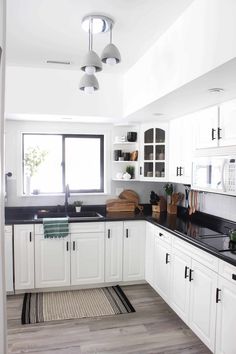 the kitchen is clean and ready for us to use it's counters are white with black counter tops