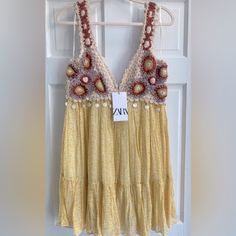 a yellow dress hanging on a door with a tag in front of it that says ava