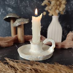 a white candle sitting on top of a plate